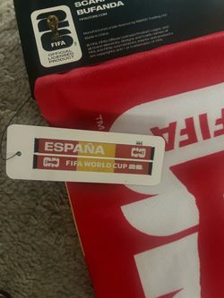 official FIFA licensed red fan scarf featuring black fringe trim and an "España" tag.