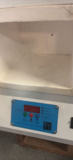 White electric kiln has a digital control panel. Control panel has options for PMC Fast, PMC Slow, and PMC Standard firing modes. Also has temperature