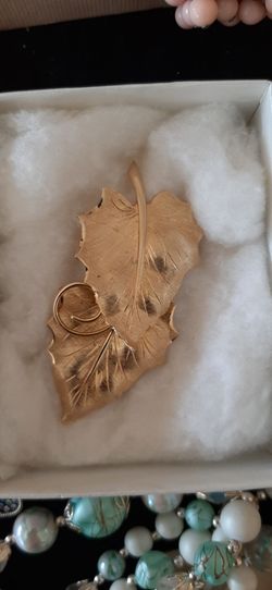 Elegant gold tone double leaf design brooch.