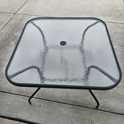 Glass patio table with umbrella holder