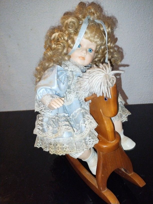 Porcelain Doll On A Wooden Horse