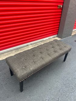 upholstered button-tufted bench detailed with decorative nailhead trim