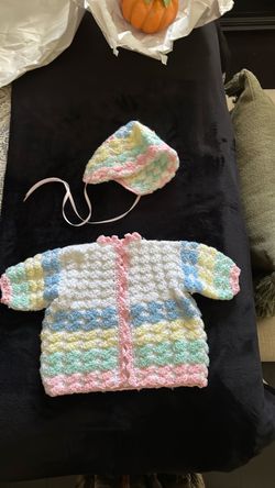 Hand crochet baby sweater with matching hat.
