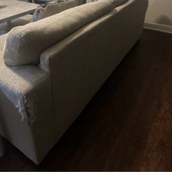 beige sectional sofa set with matching patterned pillows.
