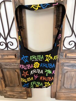 Black canvas shoulder tote bag featuring colorful repeating "Aruba - One Happy Island