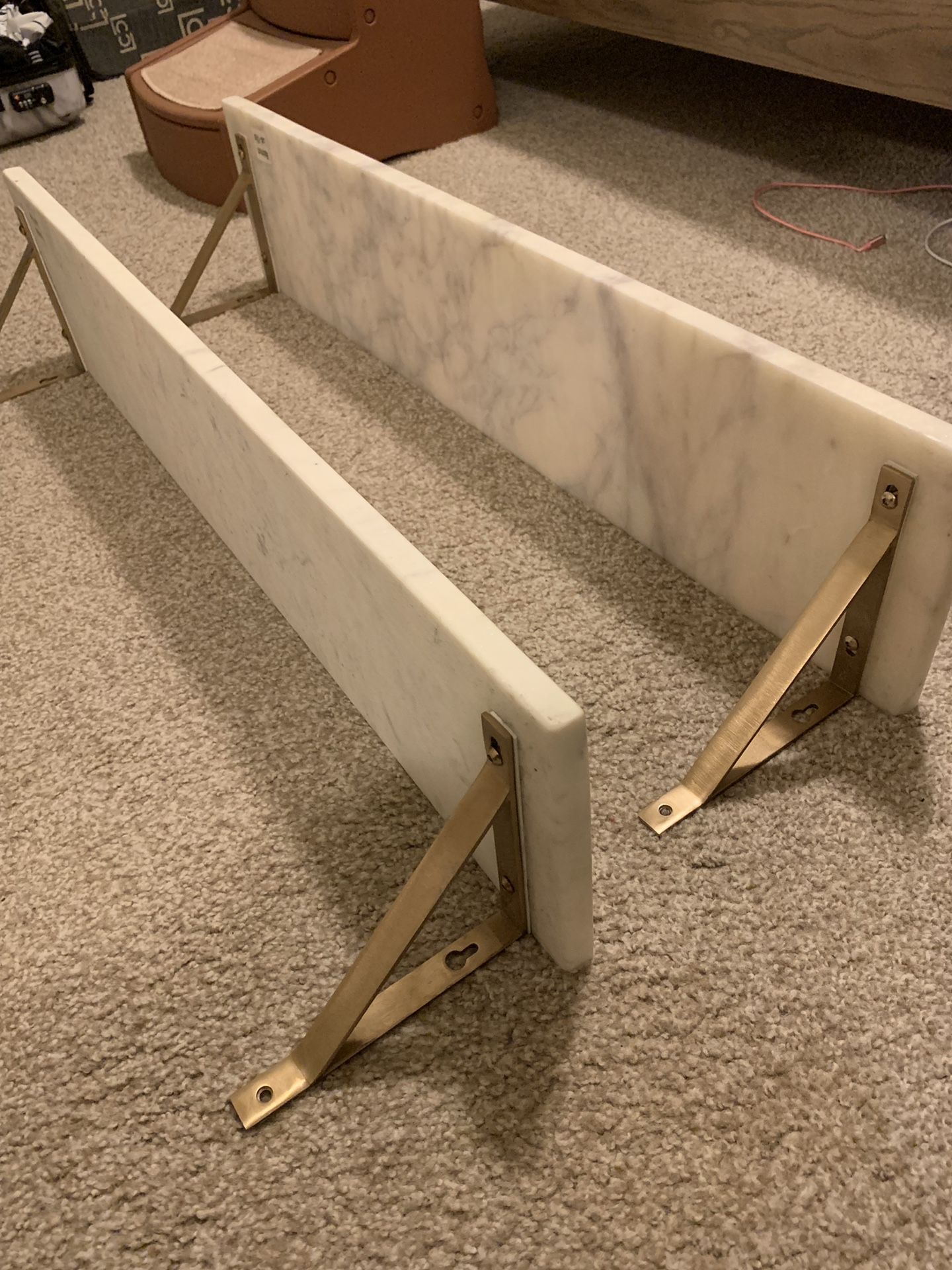 World Market white marble wall shelves with gold metal brackets