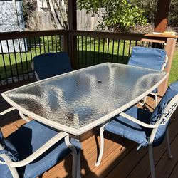 Outdoor glass and metal patio table and four chairs