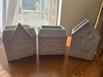 Three white ceramic house planters