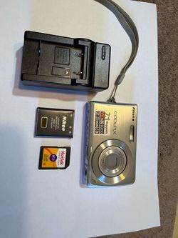 Silver Nikon Coolpix S200 digital camera has a 7.1 megapixel sensor and a 3x optical zoom Nikkor lens. This compact point-and-shoot includes a 2.5-inc
