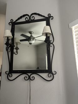 Vintage wrought iron wall mirror with dual candle-style sconces and pleated shades
