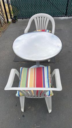 Stainless steel cafe table and two plastic chairs