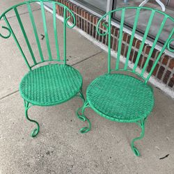 Two wrought iron green patio chairs 