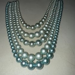 A vintage multi-strand faux pearl necklace with an ombre blue-teal gradient.