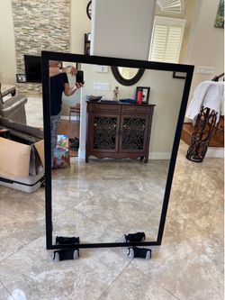 Large mirror mounted on black wood