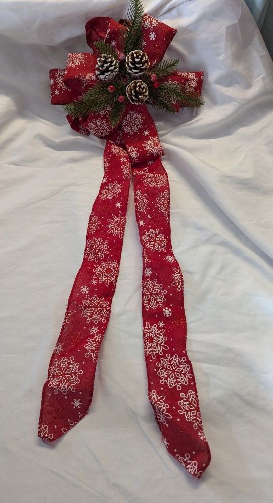 Pine cone, red berry and evergreen bow for door, present or wall decoration.