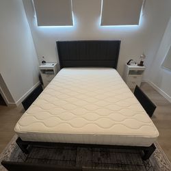 Queen size gray cloth bed frame with mattress and drawers.