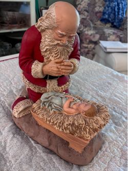 Sculpture of Santa kneeling at the manger