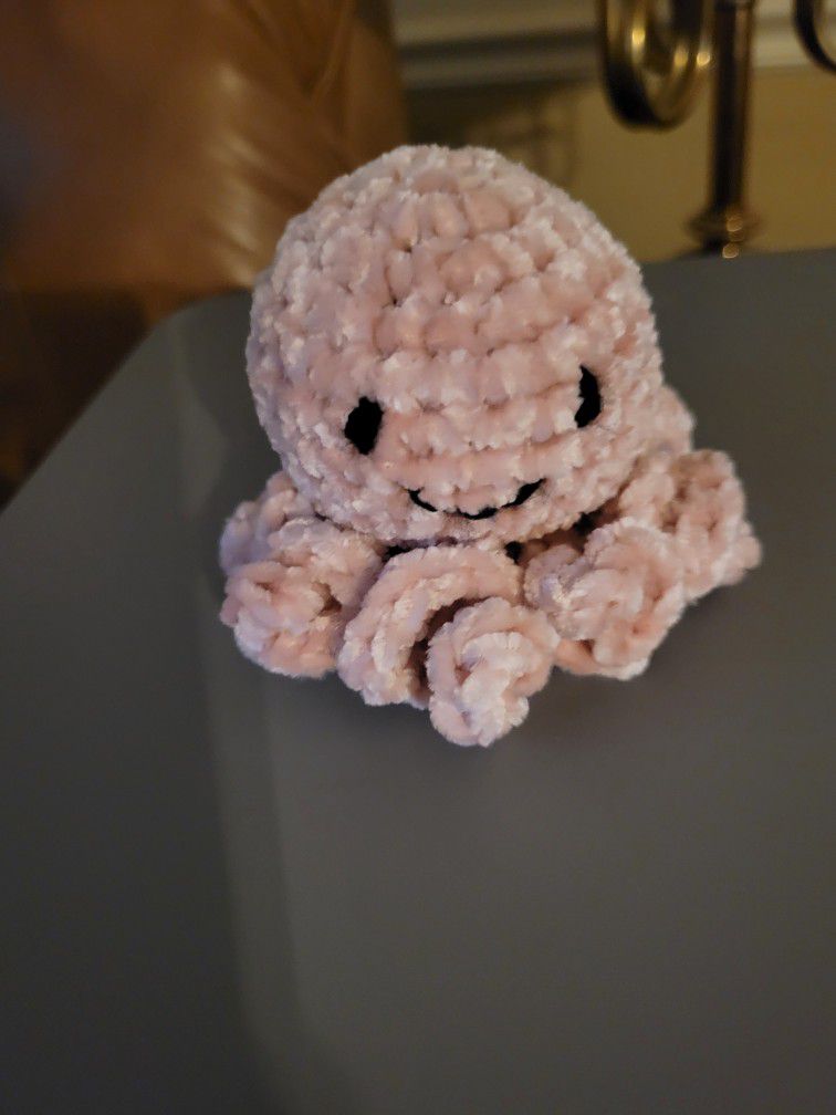 Crocheted octopus made with velvet yarn that can fit in the palm of your hand. 