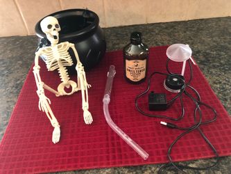 Halloween-spooky skeleton in misty cauldron with floating potion bottle