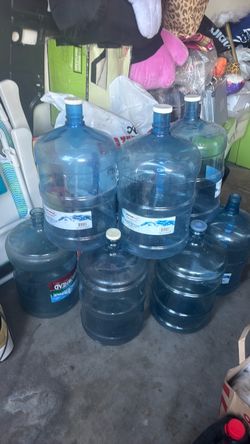 Seven 5-gallon water bottles