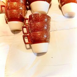 maroon/reddish-brown rim with an ornate 22k gold overlay pattern and a floral center design. 