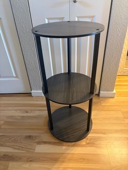 3-tier round accent table or display shelf with a dark, faux-wood finish