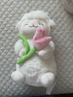 Lamb plush holding a flower
