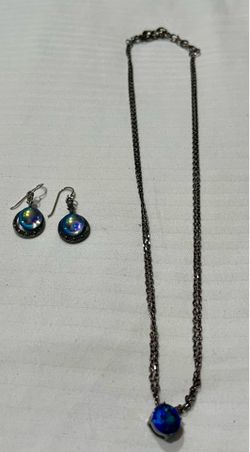 pendant necklace and a pair of dangle earrings featuring vibrant, iridescent blue cabochons.