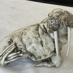 Glazed ceramic sculpture of a walrus with mottled brown and cream finish.