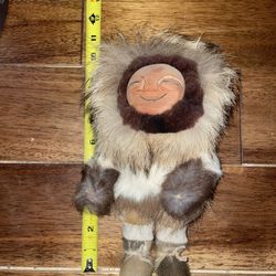 vintage handmade Inuit or Alaskan Eskimo doll crafted from natural materials like hide, leather, and fur. 