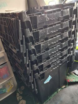 Black industrial plastic totes with hinged tops and grated bottoms