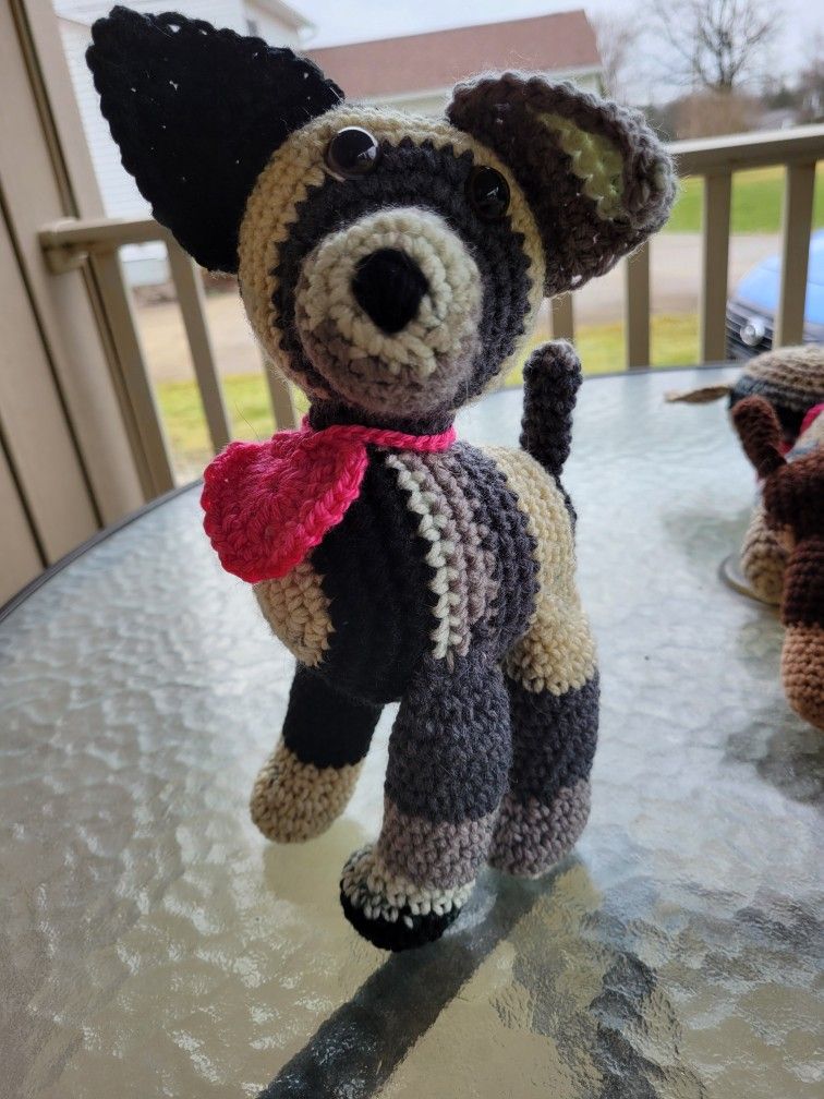 Hand crocheted black, gray, white and tan dog with heart collar.