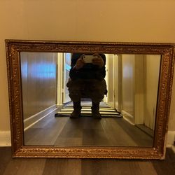 vintage wall mirror featuring a large, ornate, with golden decorative frame . 