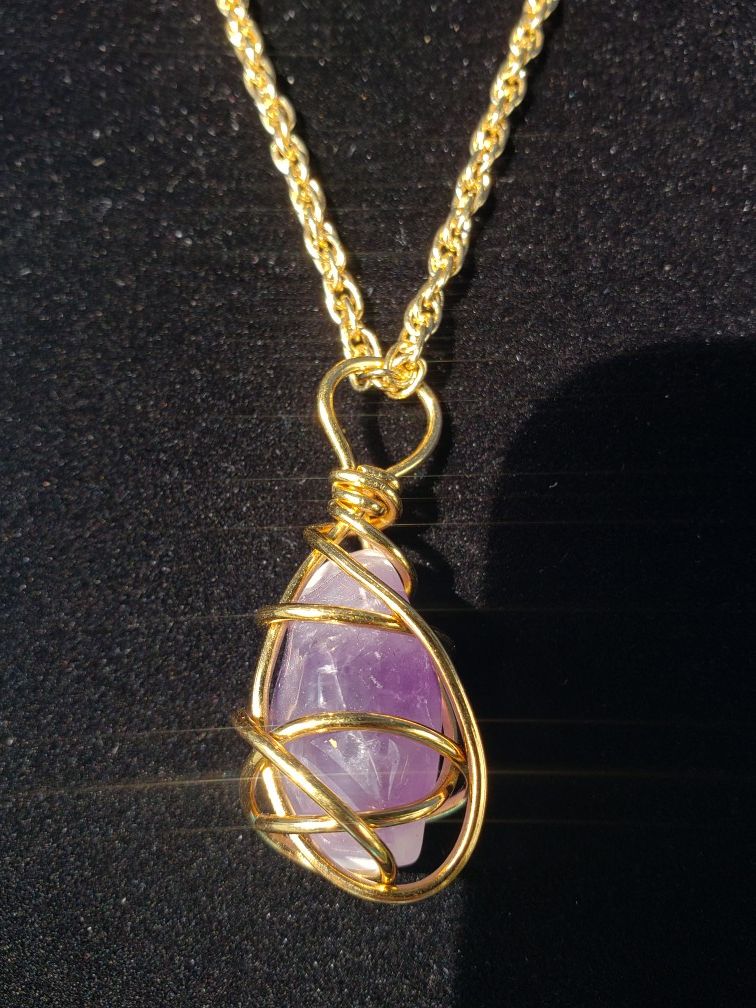 $10. Single vintage amethyst wire wrapped stone on a gold plated chain by Avon. Necklace is 30 in. Pendant is 1 5/8 in long and 3/4 in wide.