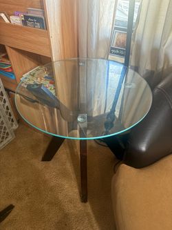 vintage/mid-century-style round glass dining table with a sculptural wood base. Dining table set