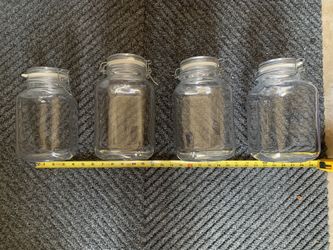 Preowned set of four large glass jars for sugars etc