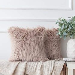 pair of fluffy, champagne color,  faux fur throw pillows with a soft, shaggy texture.