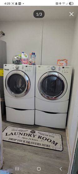 White Maytag front-load washer and dryer set with matching pedestal bases.