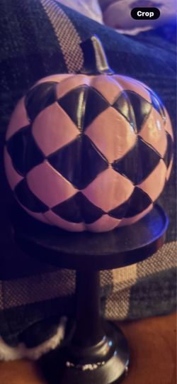 Pink and black pumpkin on pedestal