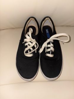 Classic black canvas sneakers, identified by their silhouette and insole label as the iconic Keds Champion model. Size 8