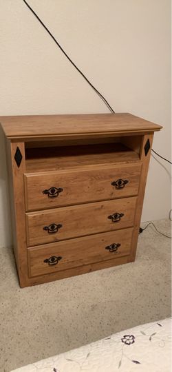 Rustic media three drawer chest features an open top cubby shelf and distinctive black diamond decorative accents.