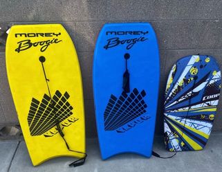 yellow Morey Boogie Valor, a blue Morey Boogie Valor, and a smaller patterned Coop bodyboard.
