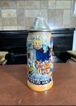 Vintage German ceramic beer stein featuring a high-relief tavern scene with a pewter-hinged lid