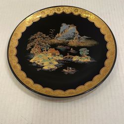 This vintage Japanese ornamental plate features a hand-painted mountain landscape scene