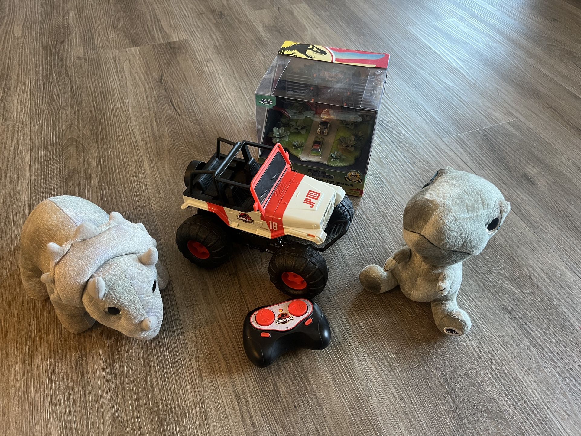 Jada Toys Jurassic Park merchandise, including a remote-control vehicle and plush toys. Exciting remote control off-road vehicle set featuring plush