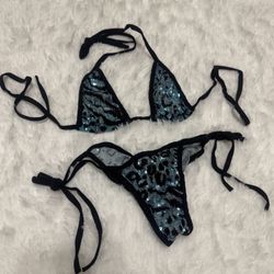 Two-piece sequin bikini with teal glitter sequin animal print. Black trim and adjustable tie straps. Sparkly, eye-catching beachwear. Comfortable tria