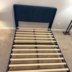 Selling my queen size bed frame for 60$. It has wooden slats, a large comfy back with a checkered pattern. Navy blue color and the headboard is made o