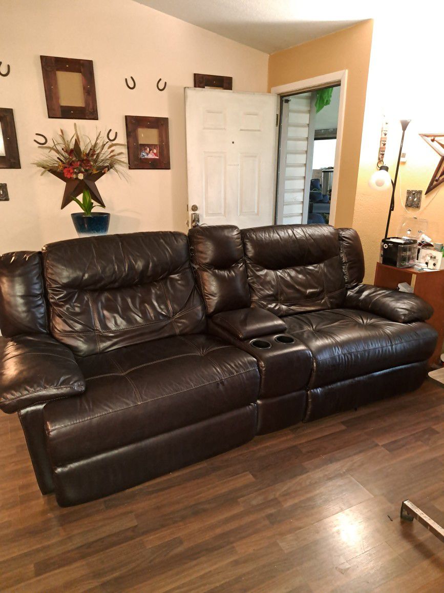 Couch with two reclining sides and a table in the center.