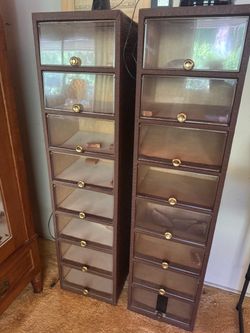 two tall, narrow, dark brown multi-drawer storage cabinets