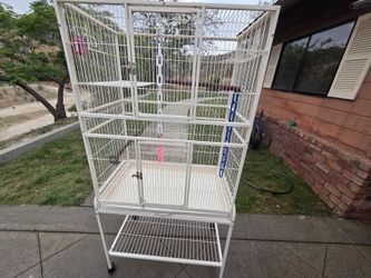 Large white metal bird cage on wheeled stand